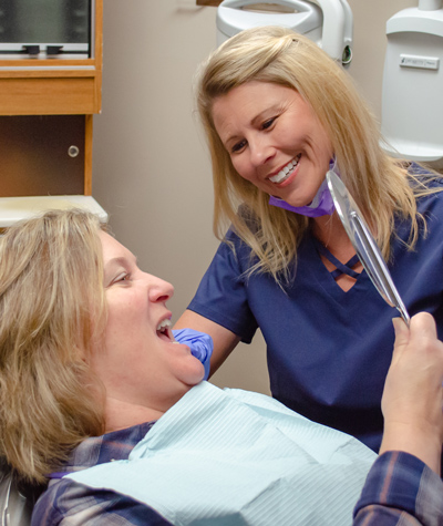dental hygienist checks patient's teeth